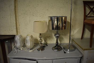 une commode blanche sur laquelle sont posées deux lampes