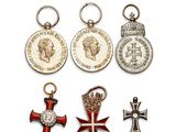 quatre médailles et une médaille sont posées sur une surface blanche