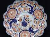 an orange and blue plate with a bird on it on a black background