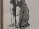 an open book with a picture of a cat and a cat statue on it