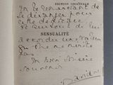 un livre ouvert avec une écriture dessus, posé sur une table