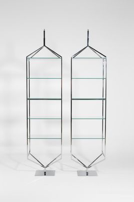 a pair of chrome and glass shelvings