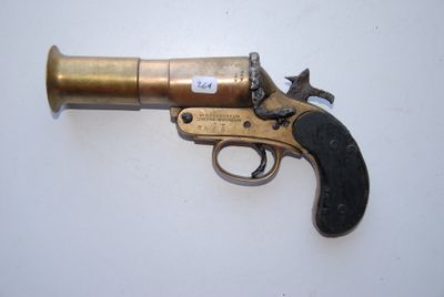 un vieux pistolet posé sur une surface blanche