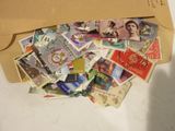 une enveloppe marron remplie de timbres, posée sur une table blanche