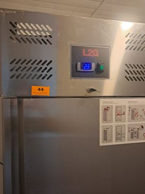 une photo d'un réfrigérateur dans une cuisine, sur lequel est posée une horloge