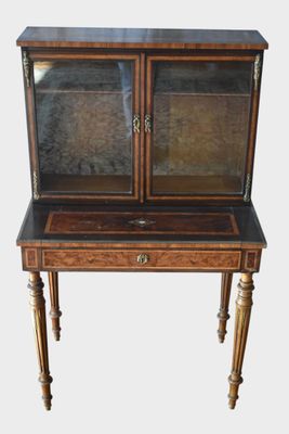 une petite armoire en bois surmontée d'une porte vitrée
