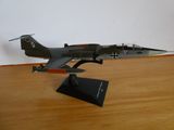 une maquette d'avion de chasse posée sur une table en bois