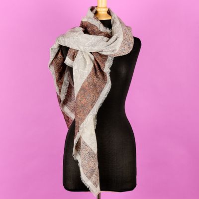 une écharpe posée sur un mannequin, sur fond rose