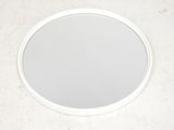 un miroir rond accroché au mur de la salle de bains
