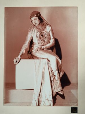 une vieille photo d'une femme assise sur une boîte blanche