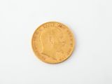 a close up of a gold coin on a white surface