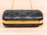 a black and gold purse sitting on top of a wooden table