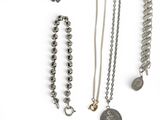 many different types of necklaces on a white surface
