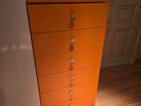 une commode orange dans un coin de la pièce