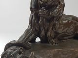 bronze statue of a lion and a dog on a wooden base
