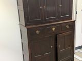 une armoire en bois à deux portes, surmontée d'un tiroir