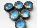 six blue glass bowls sitting on top of each other on a white surface