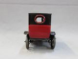 a small red and black toy car on a white surface