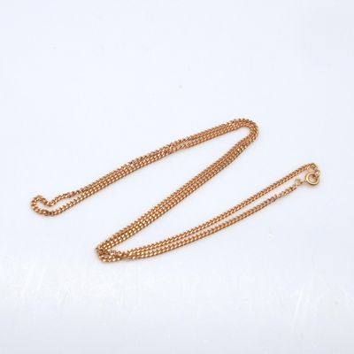 a close up of a gold chain on a white background