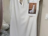 a white dress hanging on a hanger in a room