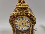 a gold clock with a statue on top of it