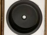 a black bowl in a cardboard box on a white surface