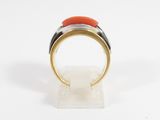 a close up of a gold ring with a red stone on it