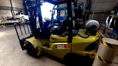 un chariot élévateur jaune garé dans un entrepôt