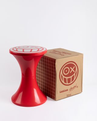 a red table with a box and a red candle holder