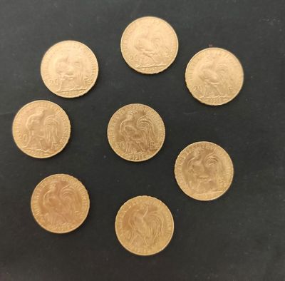 six pièces d'or sont disposées en cercle sur une surface noire