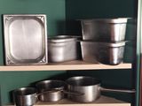 de nombreuses casseroles et poêles sur les étagères de la cuisine
