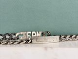 un bracelet en argent gravé d'un prénom, posé sur une table