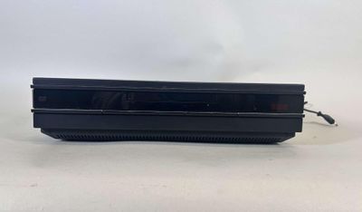 une console de jeux vidéo noire posée sur une table blanche