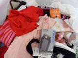 a pile of clothes that is sitting on a bed