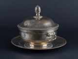 a silver plate with a silver lid and a silver plate with a silver plate on it