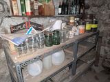 une étagère sur laquelle sont posées des bouteilles et des bocaux, dans une pièce