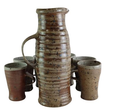 four cups and a pitcher sitting next to each other