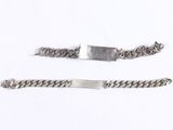 two silver bracelets and a silver plate on a white surface