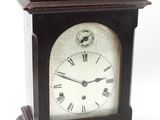 une petite horloge en bois à laquelle est attachée une clé