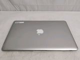 a silver apple laptop sitting on a white surface