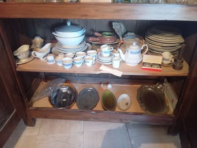 une étagère en bois sur laquelle sont posés de la vaisselle et des bols
