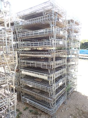 a large stack of metal cages sitting on the side of the road