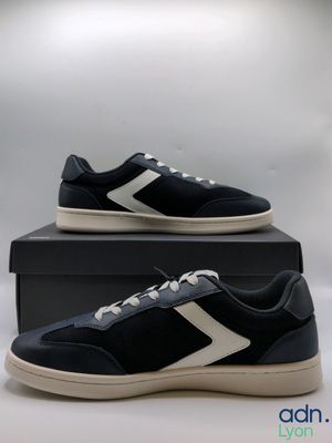 a pair of black and white sneakers sitting on top of a box