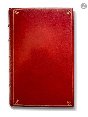 un vieux livre à la couverture rouge et à la bordure dorée