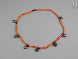 un gros plan d'un collier orné de clochettes posé sur une surface grise