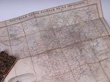une carte et un livre posés sur une table blanche