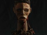 une vieille tête en bois surmontée d'une couronne