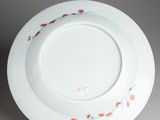 a close up of a white plate with red flowers on it