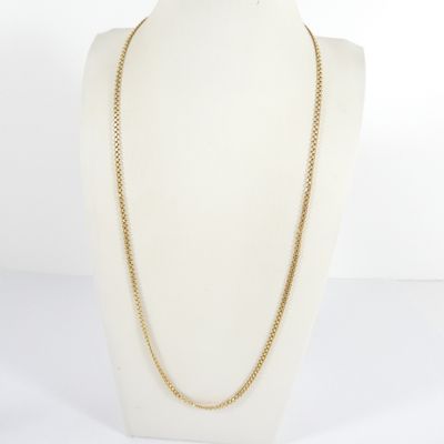 un collier à chaîne en or sur un torse de mannequin