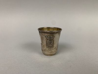 une vieille coupe en argent posée sur une table blanche